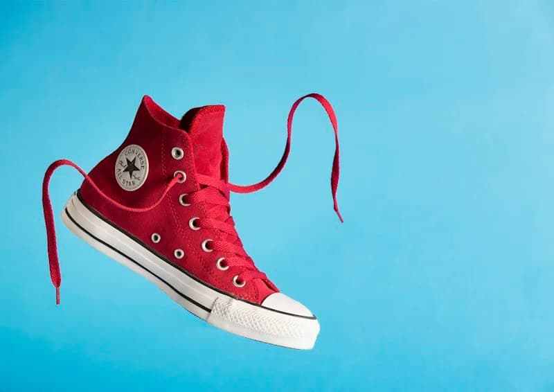Red Converse high-top sneaker against a bright blue background.