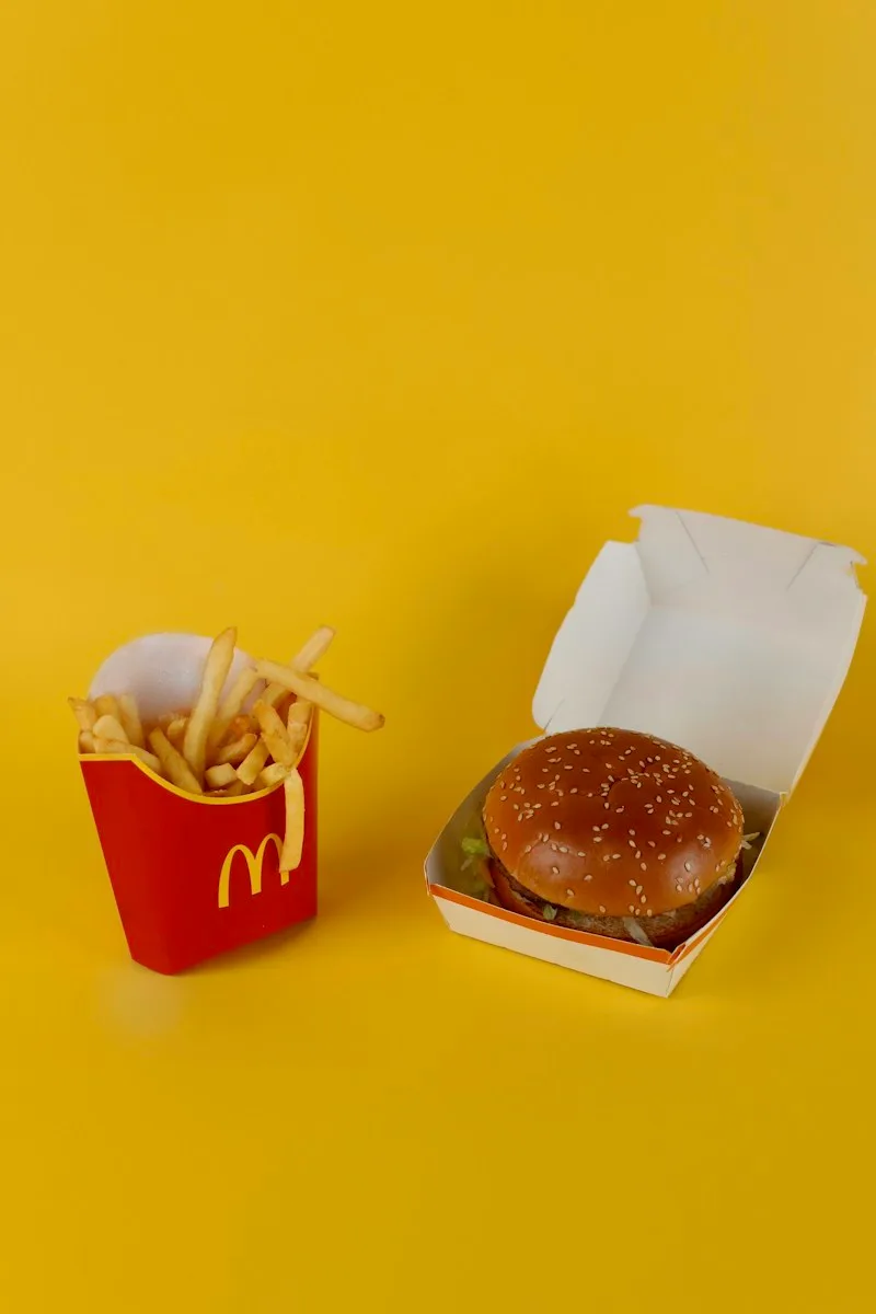 McDonald’s fries and a burger against a yellow background.